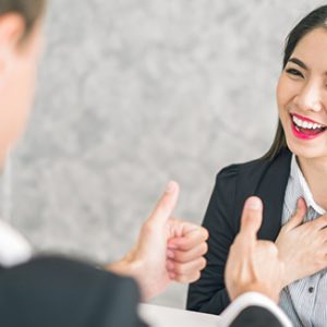 Employer gives a thumbs-up sign to his employee for a good job