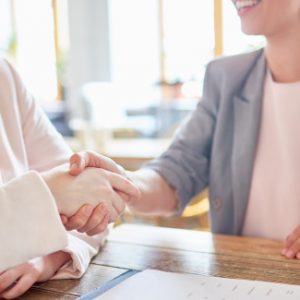 Hiring manager shakes hands with an applicant after a successful interview